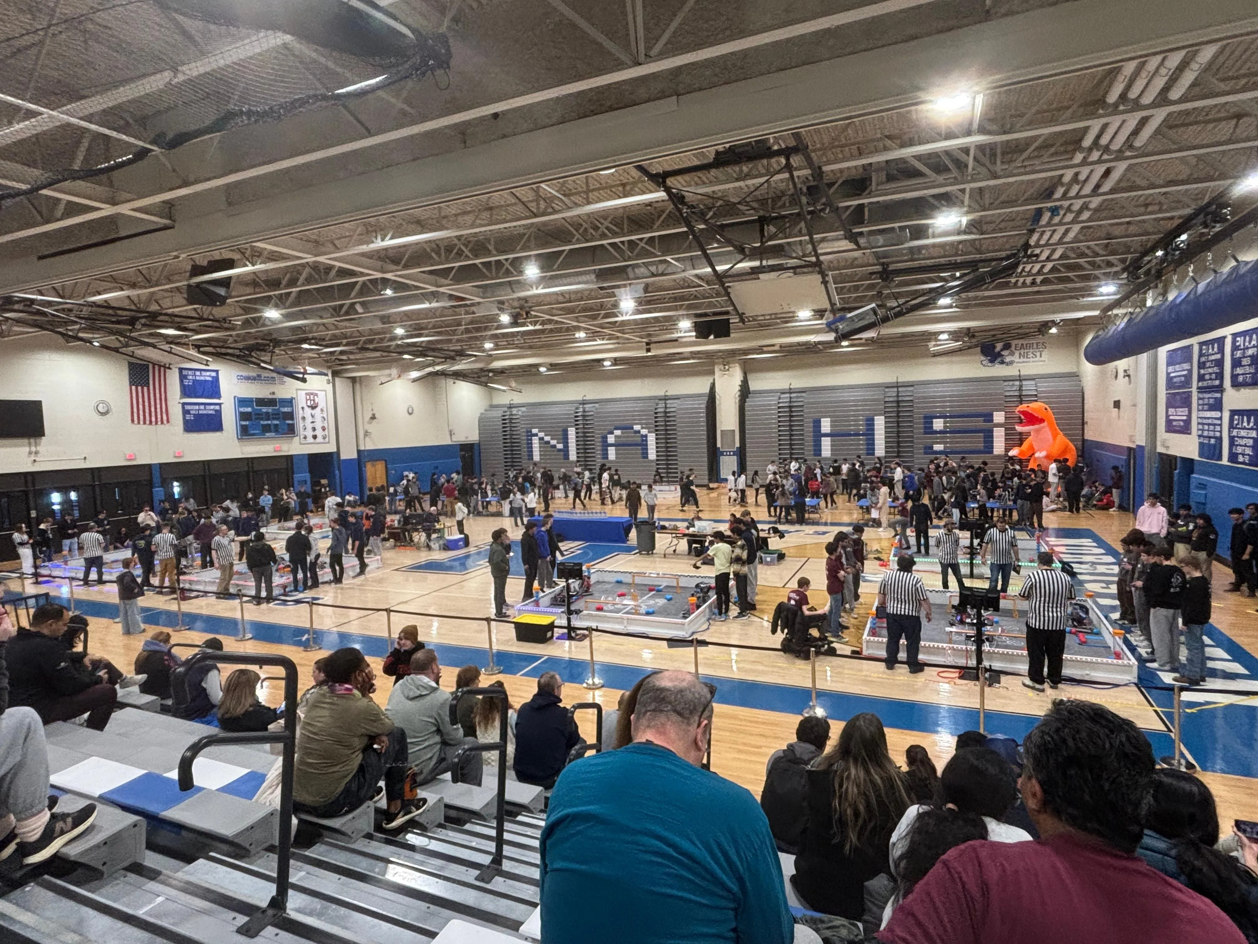 A packed high-school gym hosting a VEX tournament.